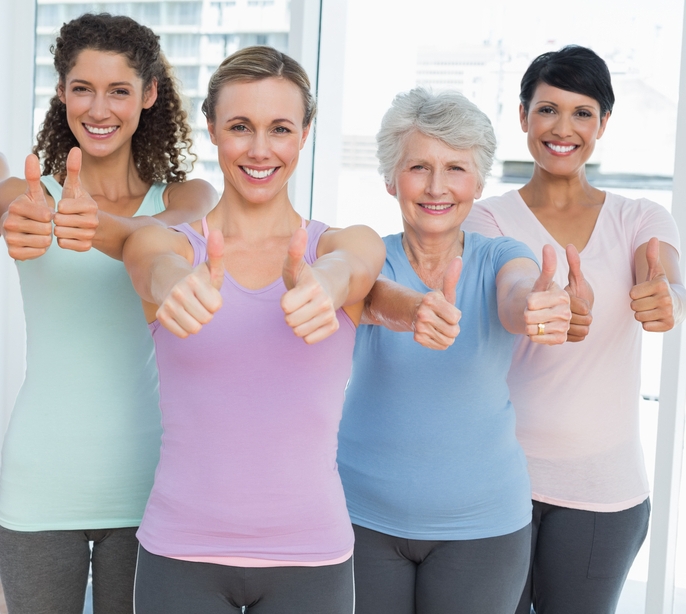 Portrait of smiling women gesturing thumbs up in the yoga class